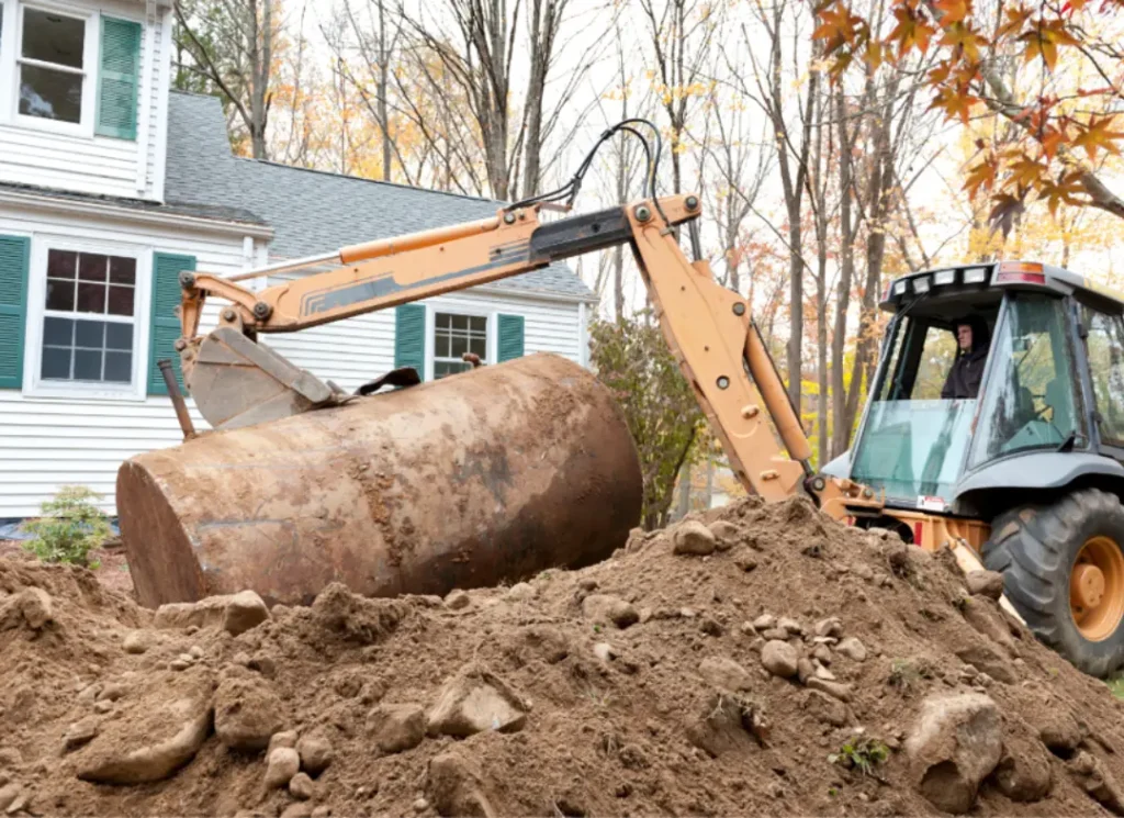 Excavator lifting large Tank.